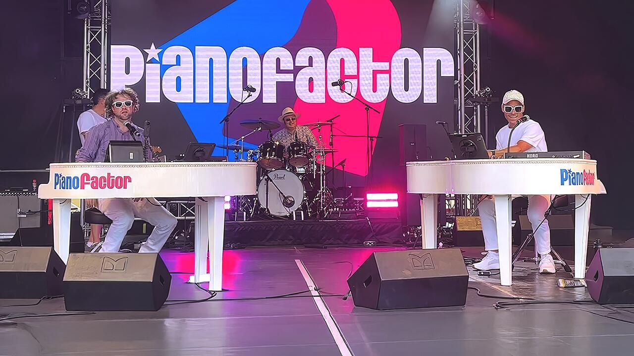 Two piano entertainers performing face-to-face with audience engagement during a live duelling pianos show