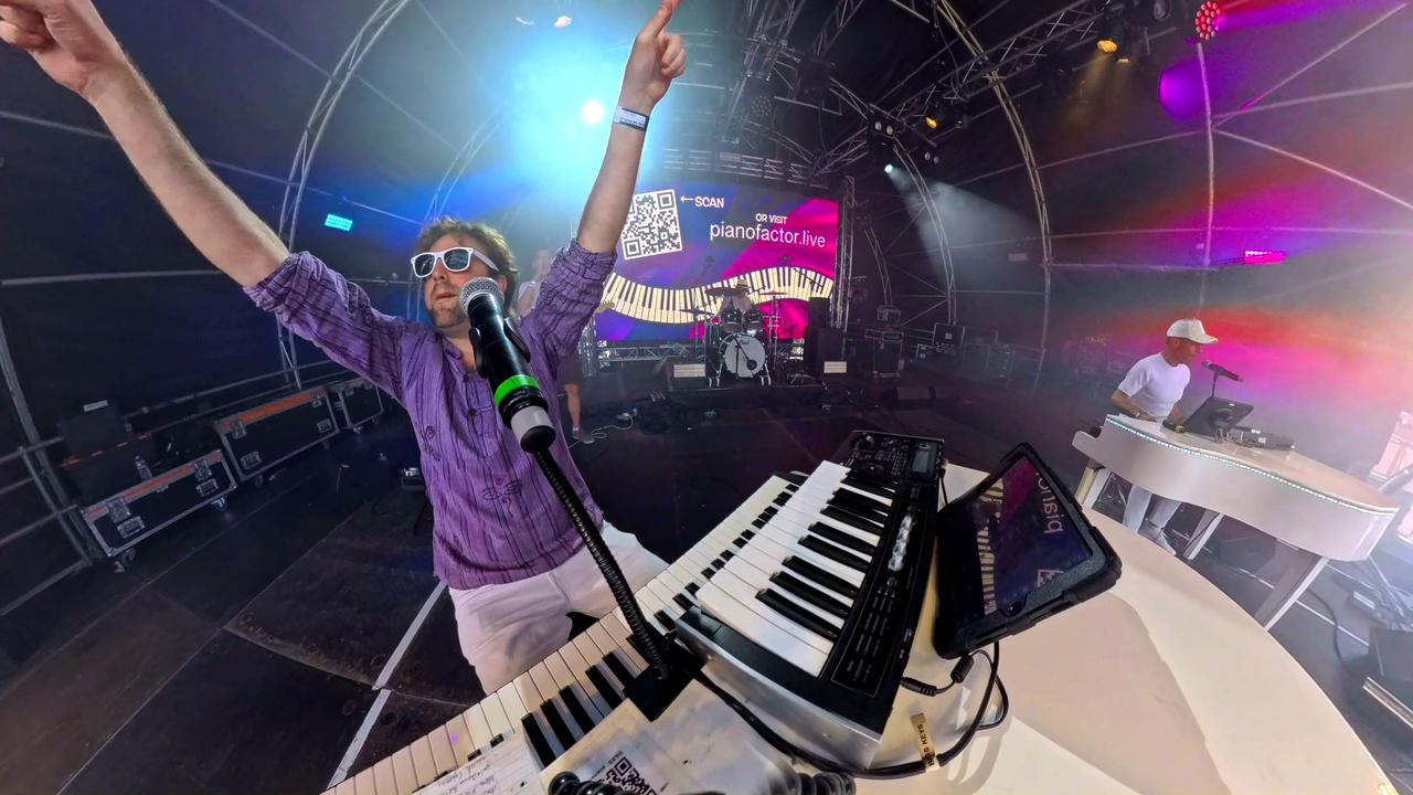 Duelling pianos performers on stage with additional musicians during a live event performance