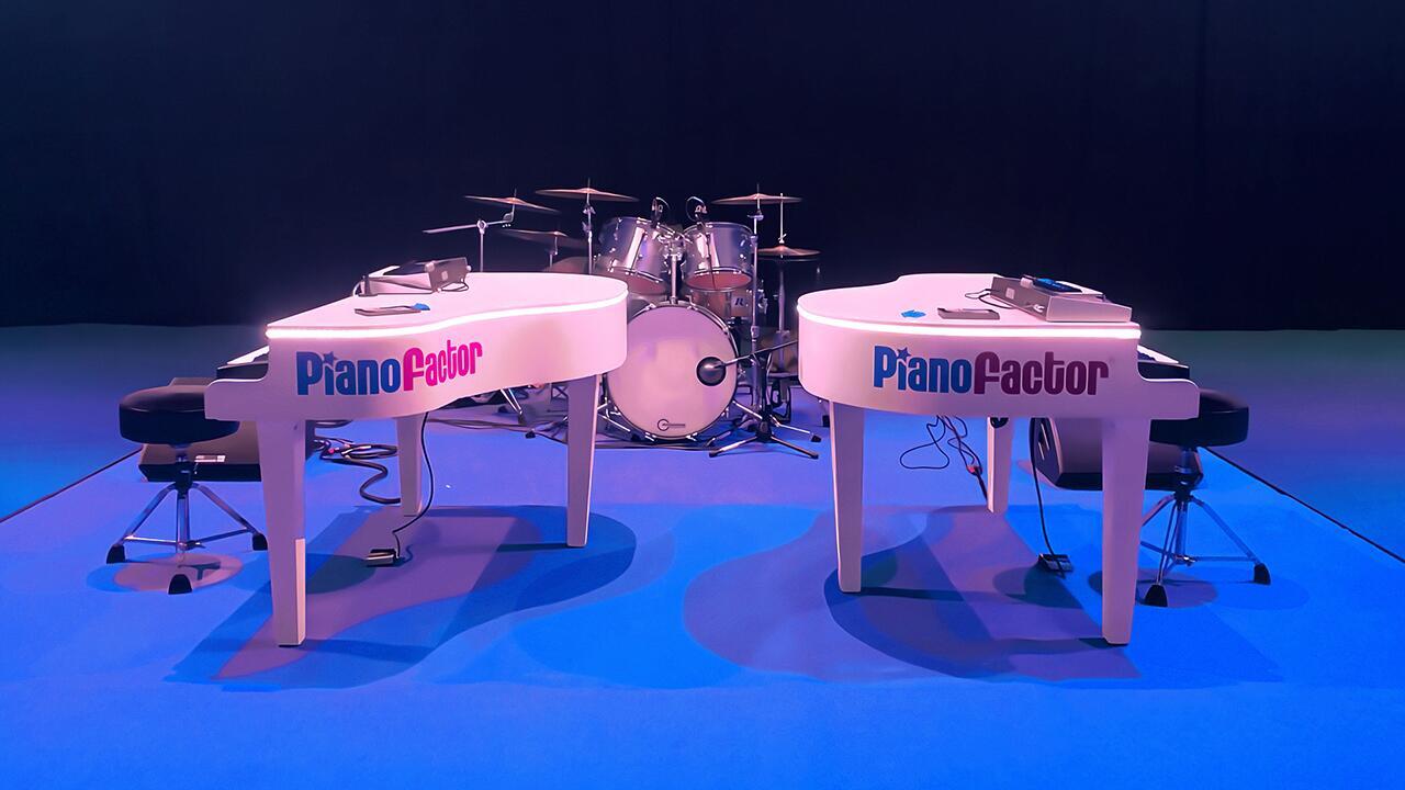 Two grand pianos positioned face-to-face on a stage ready for a duelling pianos performance