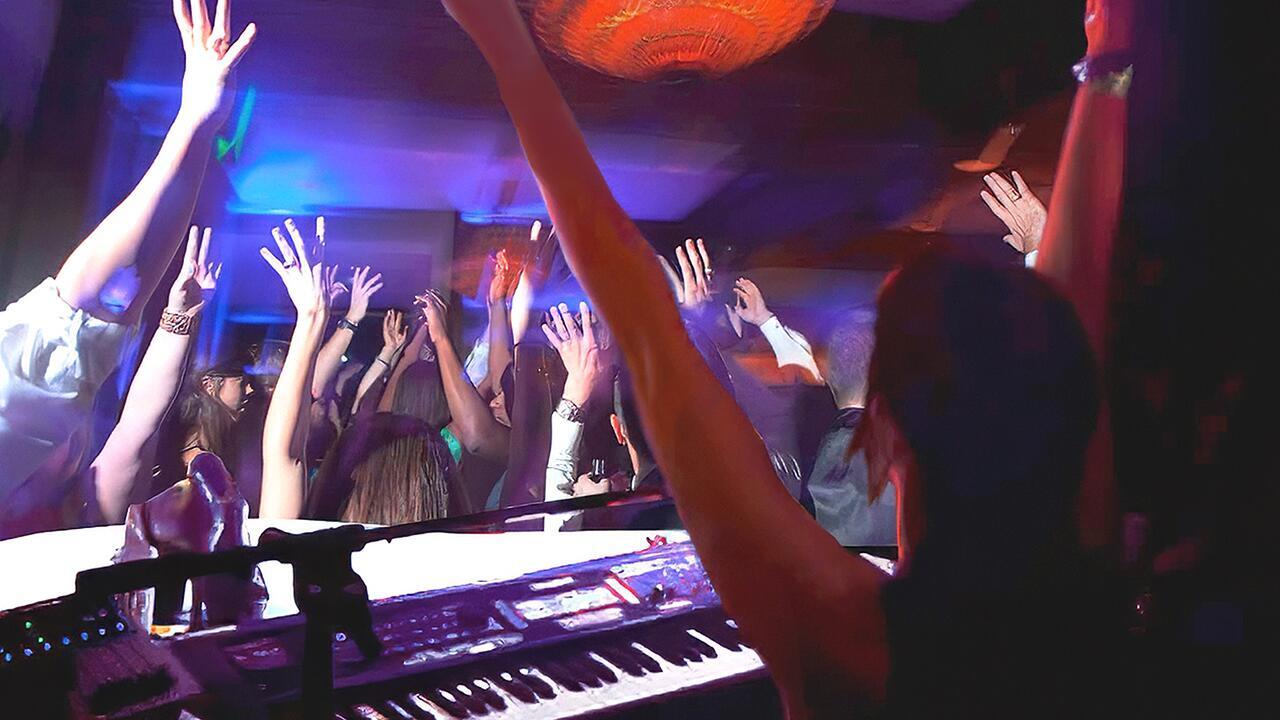 Piano entertainer  entertaining guests at a party with crowd interaction