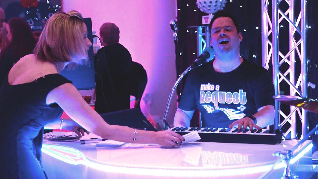 Guests gathered around the piano during a lively party performance