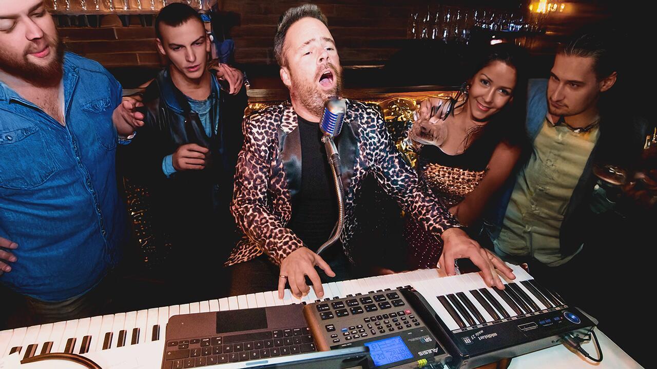 Guests interacting with a piano entertainer during a pop-up piano bar performance