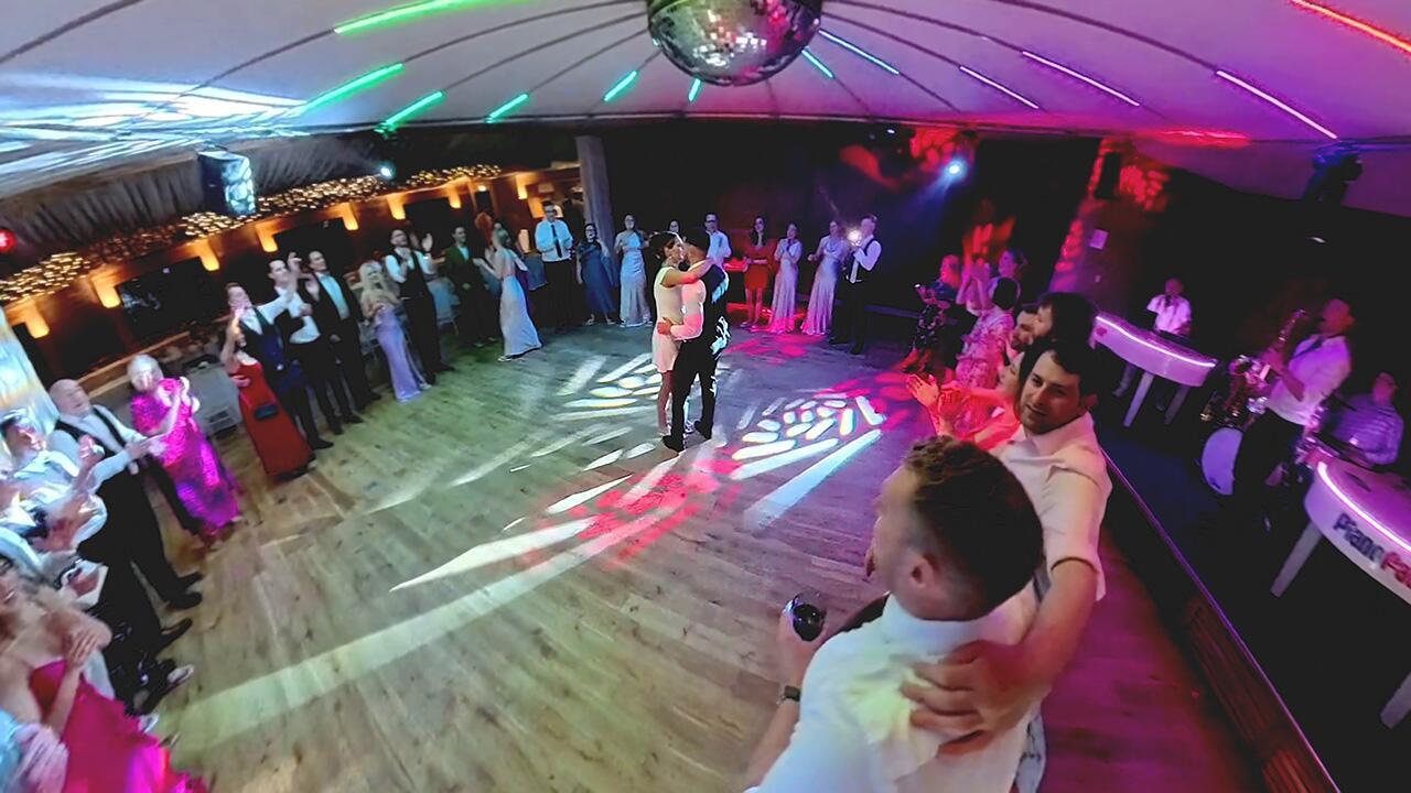 Piano entertainer performing at a wedding with guests gathered and engaged