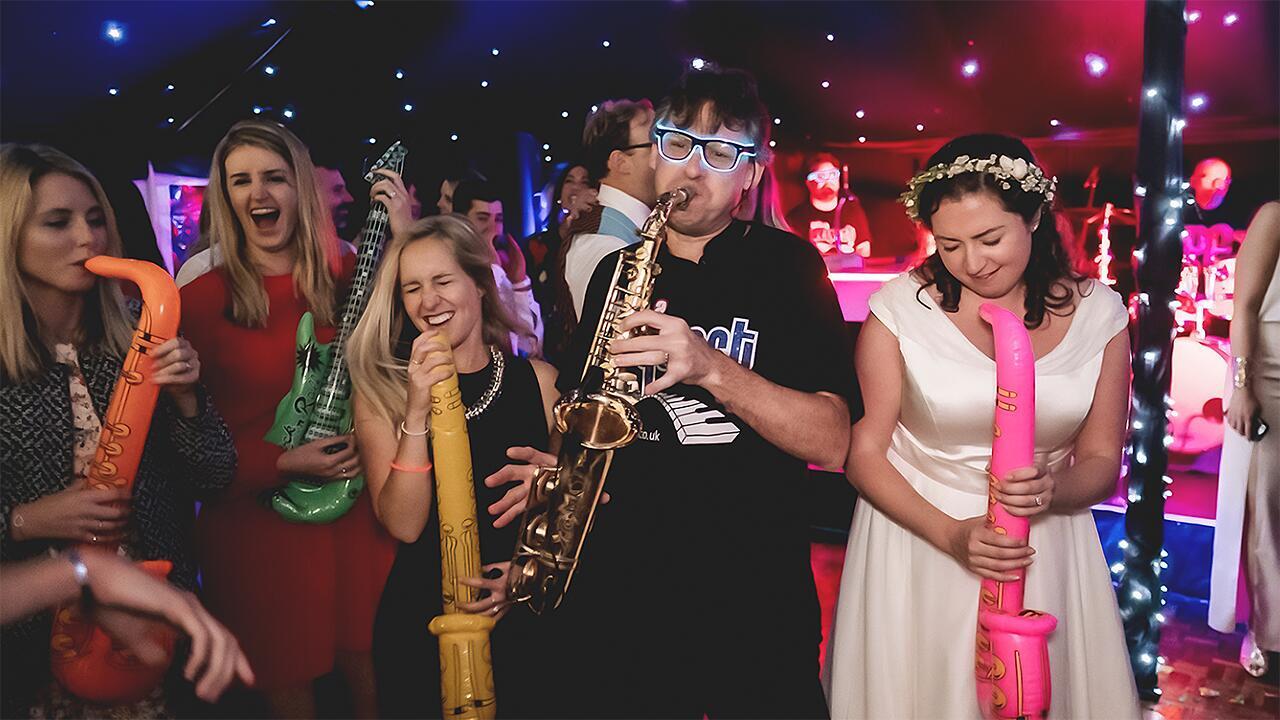 Piano entertainer performing at a wedding with guests dancing and engaging with the music